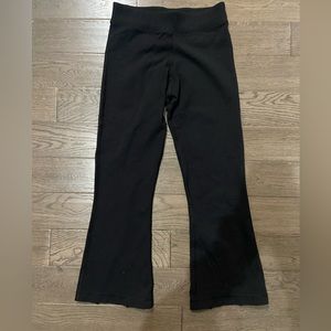 lululemon black flare cropped leggings with slits on the back ankle.